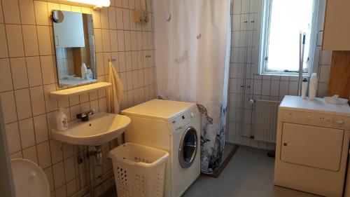 uma casa de banho com uma máquina de lavar roupa e um lavatório em Vandrehuset 2 og 3 em Nuuk