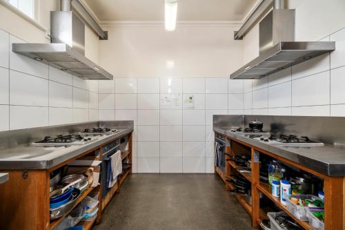 a kitchen with two sinks and a stove in it at Verandahs Parkside Lodge in Auckland