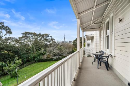 a porch of a white house with a table and chairs at Verandahs Parkside Lodge in Auckland