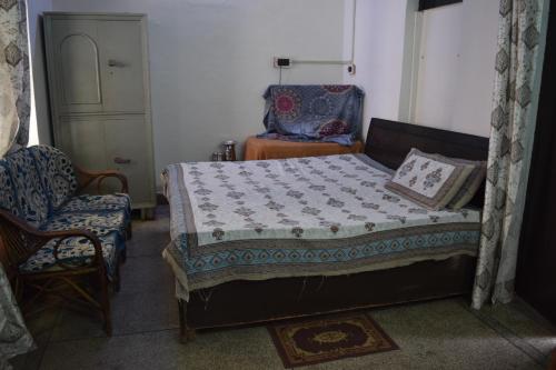 a small bedroom with a bed and a chair at hive homestay in Mathura