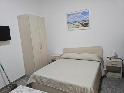 a small bedroom with a bed and two night stands at Da Massimo 1 in Marina di Schiavonea