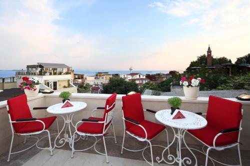 a patio with red chairs and tables on a balcony at Divalis Hotel in Istanbul
