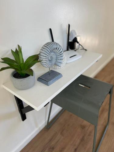 a white desk with a potted plant on it at Amori Cabin in Arorangi