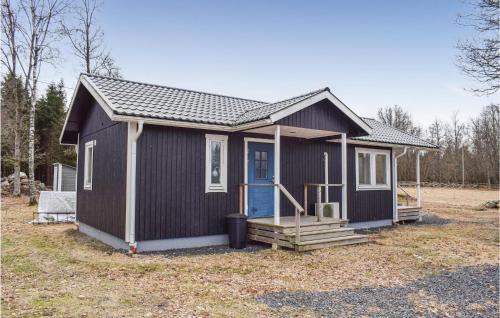 a black tiny house with a blue door at Awesome Home In Älmhult With Kitchen in Älmhult