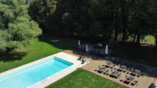 an overhead view of a swimming pool with chairs at Château - Hôtel Le Sallay in Magny-Cours