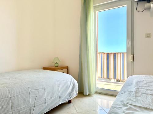 a bedroom with a bed and a large window at Apartment Elaine's View in Umag
