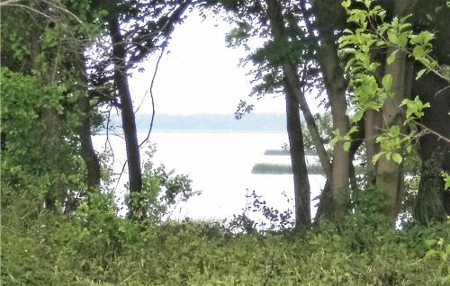 a view of a lake through the trees at Beautiful Stacaravan In Smoldzino in Gardna Wielka