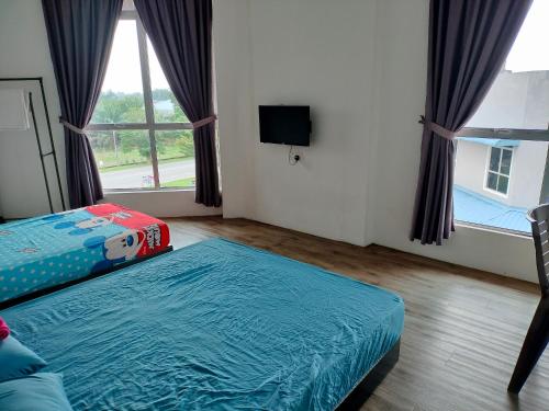 a room with two beds and a tv and a window at BENUTHOMESTAY in Johor Bahru