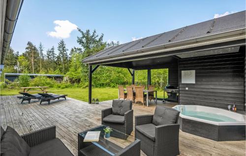 a patio with a hot tub and chairs and a table at Holiday Home Enebærvej Skjern in Lem
