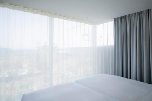 a bedroom with two beds and a large window at Simose Art Garden Villa in Kuba