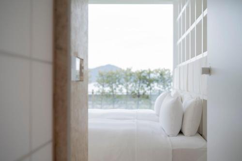 a hallway with white pillows and a window at Simose Art Garden Villa in Kuba