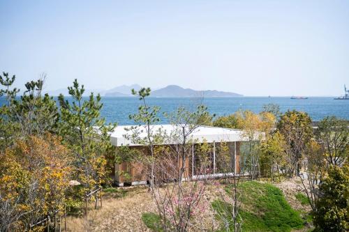 a house on a hill overlooking the water at Simose Art Garden Villa in Kuba