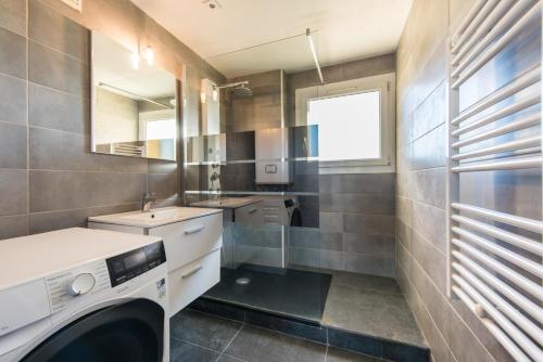 ein Badezimmer mit Waschmaschine und Waschbecken in der Unterkunft Charmant Appartement Familial in Martigues