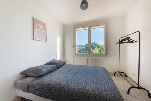 ein Schlafzimmer mit einem Bett und einem Fenster in der Unterkunft Charmant Appartement Familial in Martigues