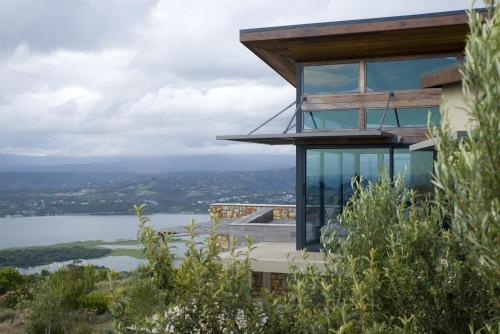 a house on a hill with a view of the water at Alkira Lodge in Brenton-on-Sea
