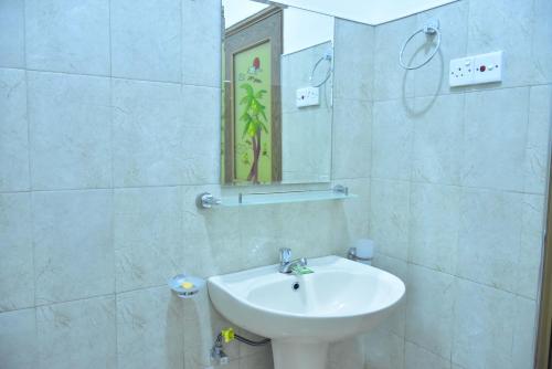 a white bathroom with a sink and a mirror at Lake Forest Lodge in Udawalawe