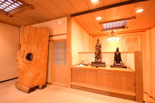 a museum with two statues on a table in a room at Koyasan Shukubo Fugenin in Koyasan