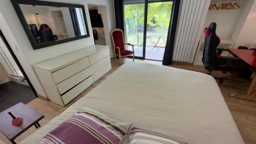 une chambre avec un lit et une commode avec un miroir dans l'établissement Maison, Piscine, Jardin & Calme, à Marseille