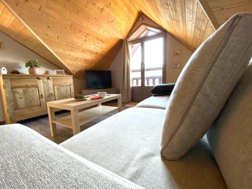 een slaapkamer op zolder met 2 bedden en een televisie bij Appartement le Dahu Risoul 1850 in Risoul