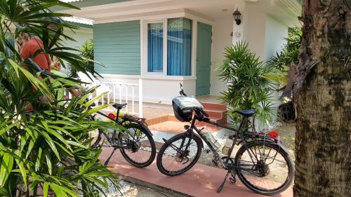 dos bicicletas estacionadas frente a una casa en Vipha Ville Resort, en Ban Huai Yang