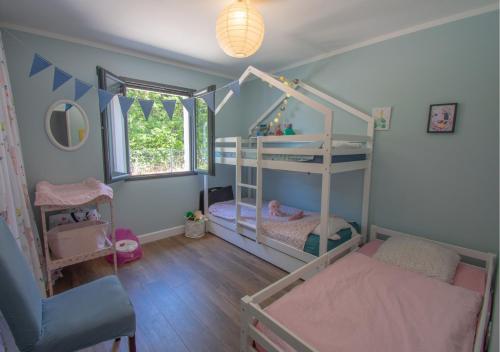 une chambre avec deux lits superposés et une fenêtre dans l'établissement Maison 110m2, piscine, 3ch, à Callian