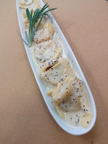 a plate of food with dumplings on a table at Agriturismo Valle Isola "La Tana del Gusto" in Comacchio