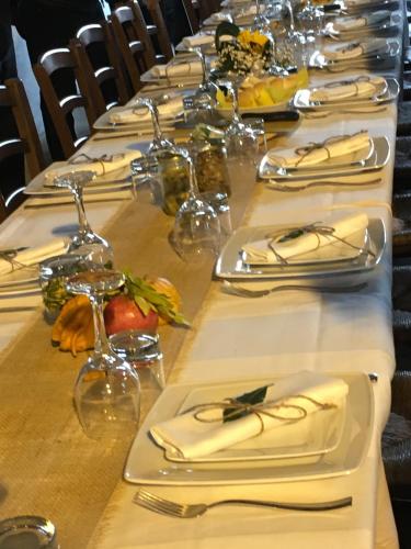 a long table with white plates and silverware on it at Agriturismo Valle Isola "La Tana del Gusto" in Comacchio