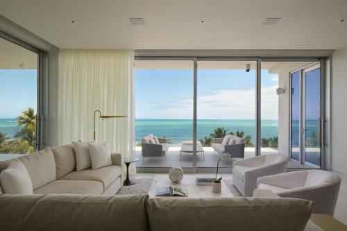 a living room with a couch and chairs and the ocean at St. Regis Bahia Beach Resort, Puerto Rico in Rio Grande