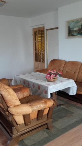 a living room with a table and a couch at Pokoje Herta - Domek letniskowy in Stawiguda