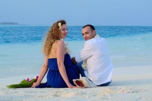 a man and a woman sitting on the beach at Ras Rana Lodge in Rasdu