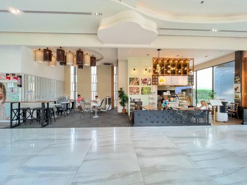 una hall con un ristorante con tavoli e sedie di The Astra Luxury Condo in Town a Chiang Mai