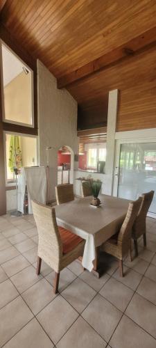 une table de salle à manger et des chaises dans une pièce dans l'établissement Maison avec piscine proche Contis plage (LANDES), à Saint-Julien-en-Born