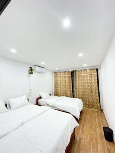a bedroom with three beds and a window at Agarwood in Hanoi