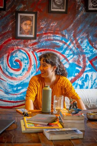 ジャイサルメールにあるOpen Road Hostel and Cafeの壁画の前に座る女