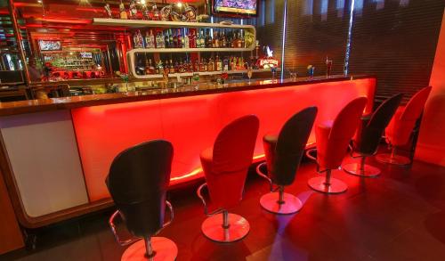 a row of red chairs in a bar with a red counter at Capitol Hill in Rānchī