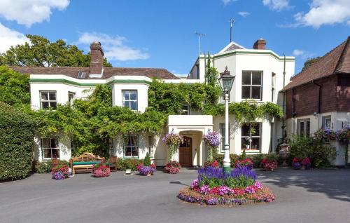 a white house with flowers in front of it at Passford House Hotel in Lymington
