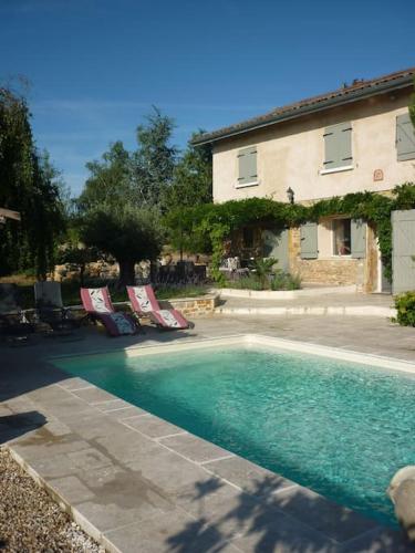 - une piscine avec 2 chaises longues et une maison dans l'établissement Beaujolais Charentay lyon Maison avec piscine, à Charentay