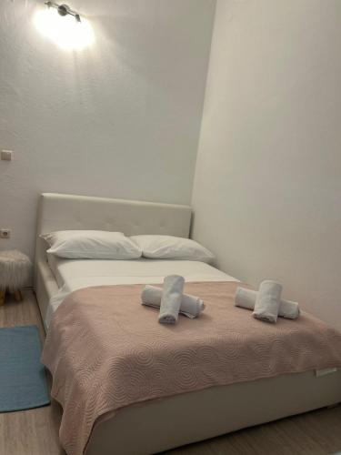 a bedroom with a bed with two towels on it at I&A apartman in Kaštela