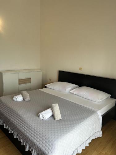 a bedroom with two beds with white sheets and towels at I&A apartman in Kaštela