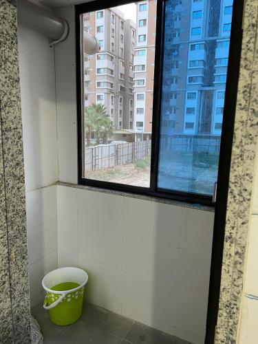 a bathroom with a window and a bucket at Aatmiya Heights in Vadodara