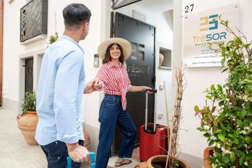 a woman standing next to a man with a suitcase at TrèSOR in Santa Teresa Gallura