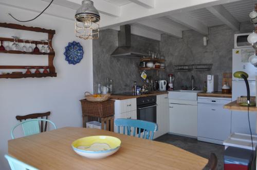 a kitchen with white cabinets and a wooden table at Casa da Nespereira in Aljezur