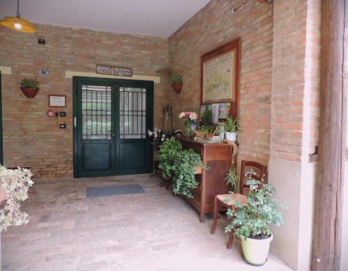 a entrance to a brick building with a black door at Agriturismo Valle Isola "La Tana del Gusto" in Comacchio