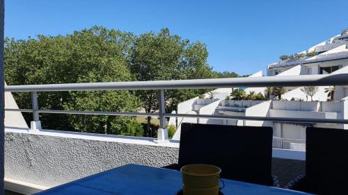 - un balcon avec une table bleue et des chaises dans un bâtiment dans l'établissement Studio rénové, proche plage couchant, 4 pers, clim, parking privé et wifi privatif, à La Grande Motte