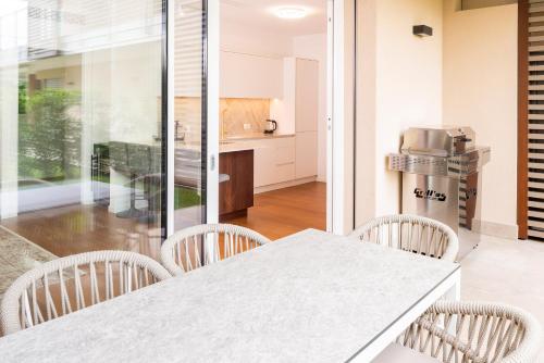 a kitchen with a white table and chairs at Lifestyle Apartments Dante in Bardolino