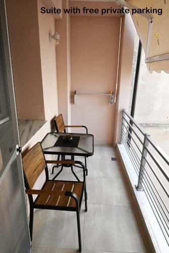 a table and chairs sitting on a balcony at Mouson Luxury Suite With Free Private Parking in Kavala