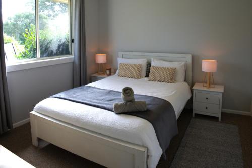 a bedroom with a bed with a stuffed duck on it at Ella's Beach Haven in Batehaven