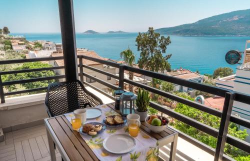a table with food on a balcony with a view of the water at True Blue Boutique Hotel Kalkan in Kalkan