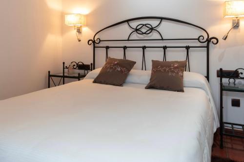 a bedroom with a large white bed with two pillows at Hotel Apartamento Marouco in A Guarda