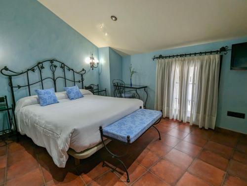 a bedroom with a large bed with blue walls at Hotel Apartamento Marouco in A Guarda